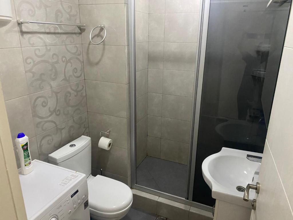 a bathroom with a shower and a toilet and a sink at BATUMi ORBI GRAND APART HOTEL in Batumi