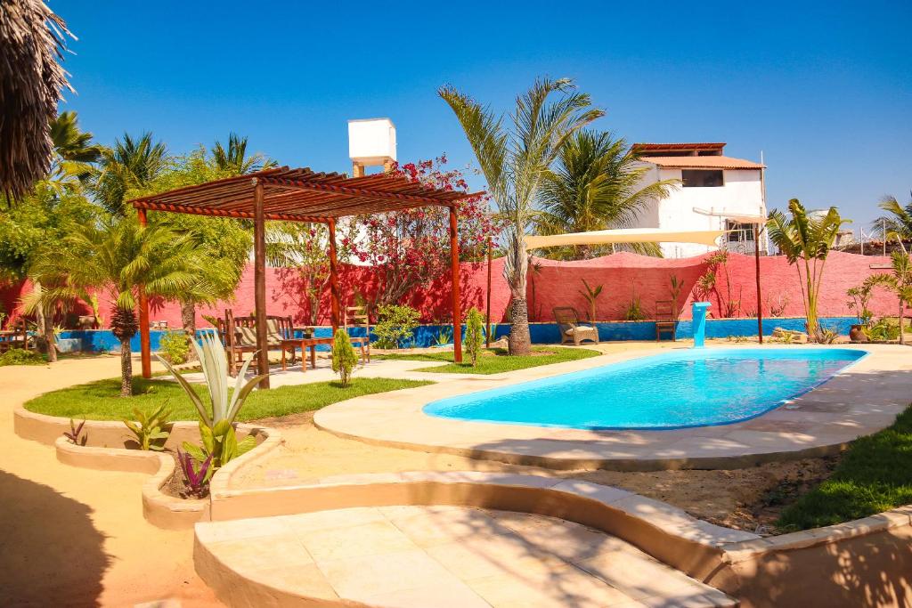 a swimming pool in front of a resort at Pousada Villa Botânica in Aracati