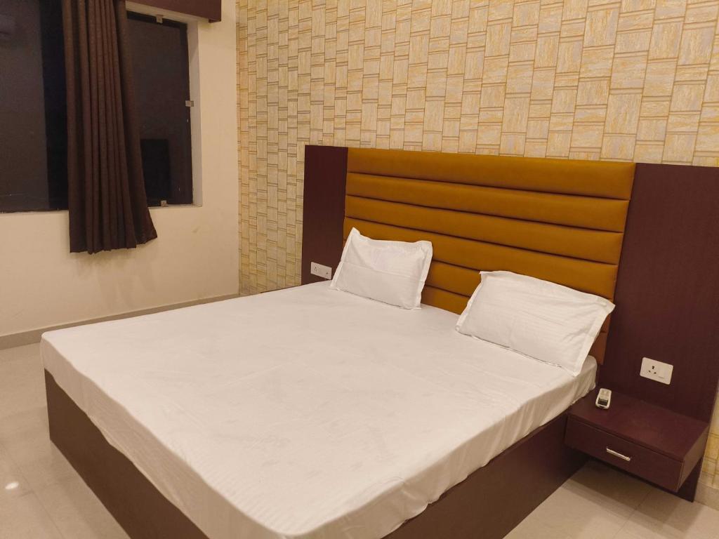 a bedroom with a large bed with a wooden headboard at Hotel O Surya Hotel in Kākori