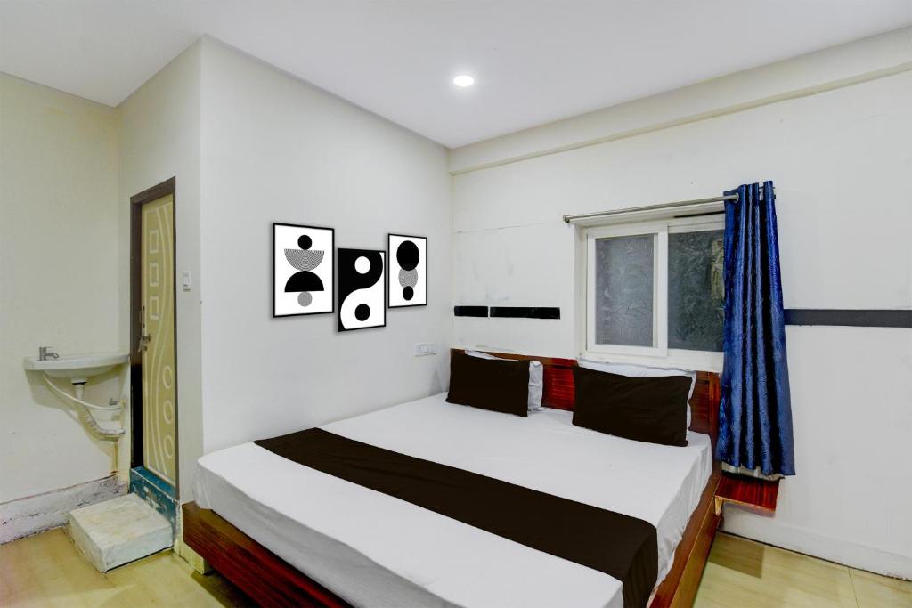 a bedroom with a bed and a window at Hotel O S V Residency in Vidya Nagar