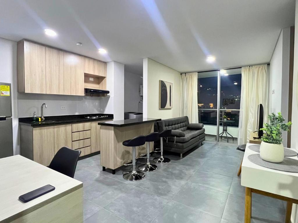 a kitchen and living room with a bar and chairs at Apartamento Familiar en Sabaneta cerca al parque in Sabaneta