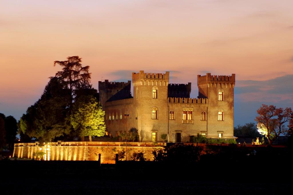 un castello è illuminato di notte di Relais Castello Bevilacqua a Bevilacqua