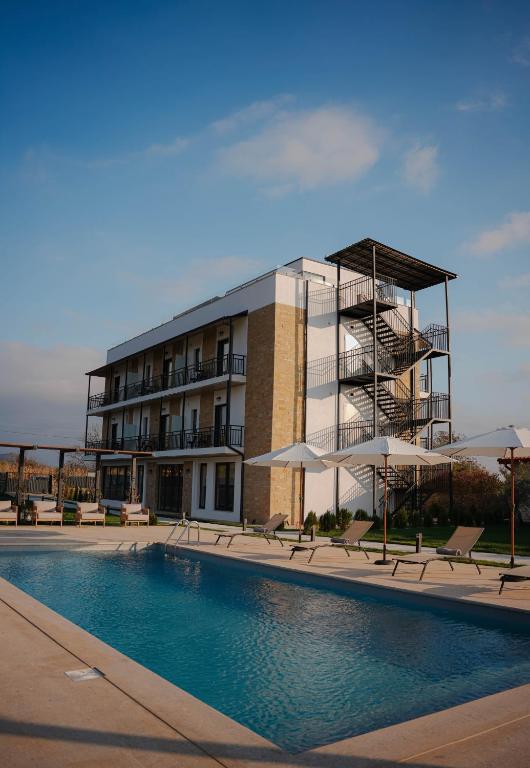 a building with a swimming pool in front of a building at Mikheili's Marani Boutique Hotel in Kvareli