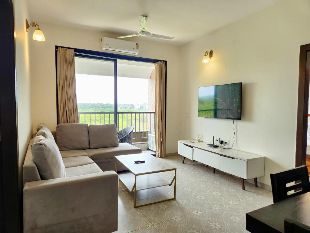a living room with a couch and a table at Ultra Luxe 2BHK Candolim Service Apartment with River and Mangrove Views in Candolim