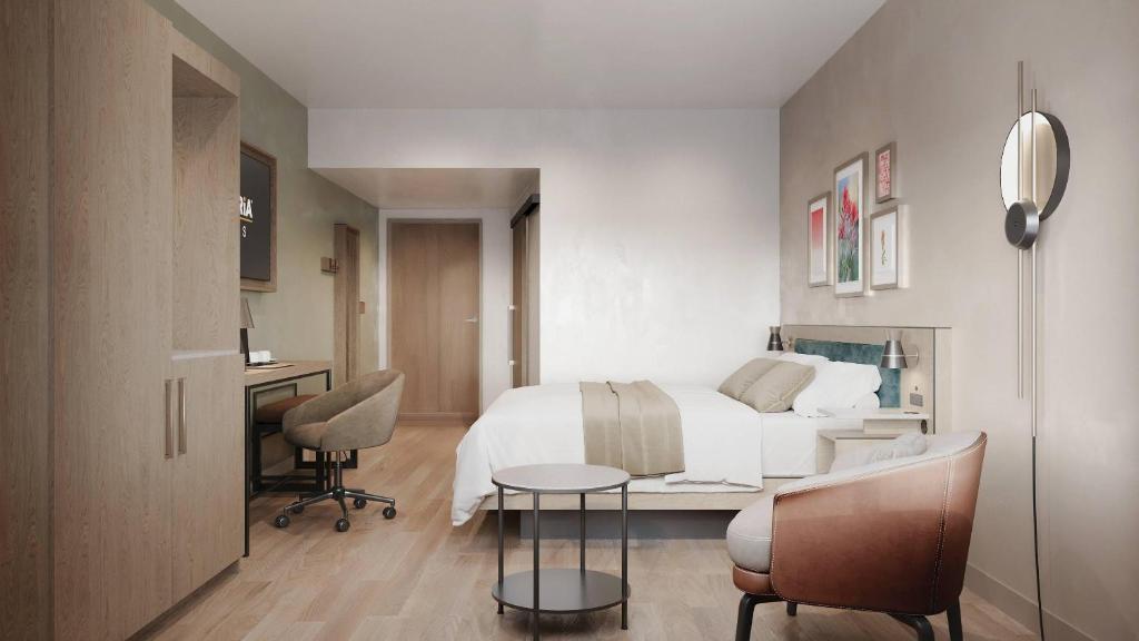 a bedroom with a bed and a desk and chairs at Cambria Hotel Euless - DFW Airport South in Euless