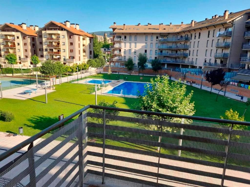 a balcony of a building with a swimming pool at Apartamentos Pilartxo Jaca 3000 in Jaca