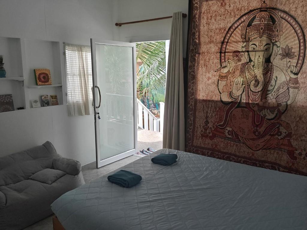 une chambre avec un lit et un tableau au mur dans l'établissement Peace home kpg, à Baan Khai