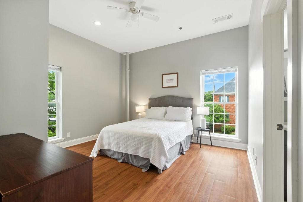 a white bedroom with a bed and two windows at New Listing Bulldog Borough in Downtown Athens in Athens