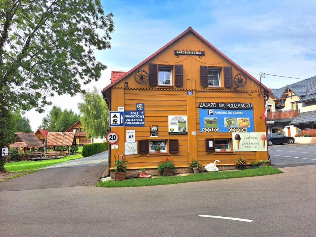 a large wooden building on the side of a road at Zajazd na Podzamczu in Pieskowa Skała