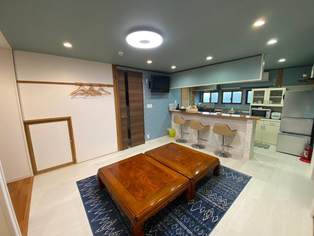 een woonkamer met een houten tafel en een keuken bij やどかり852 in Manazuru