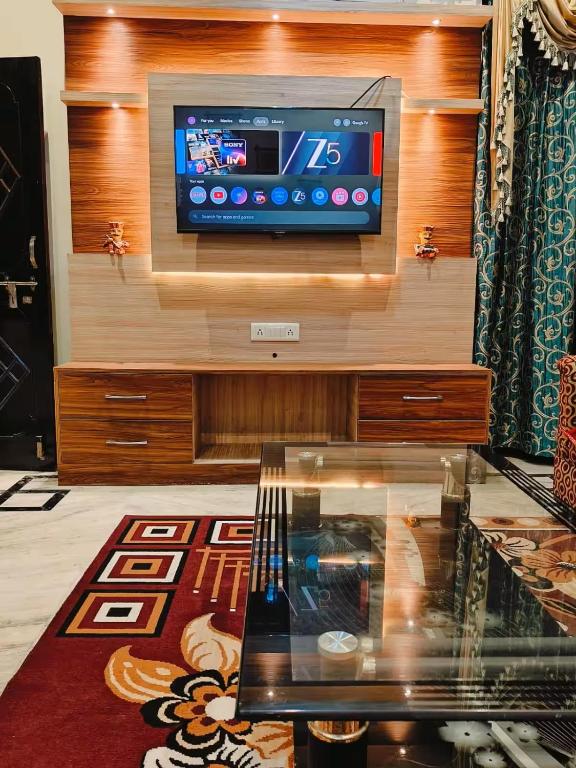 a living room with a television on a wall at Urban Retreat in Agra