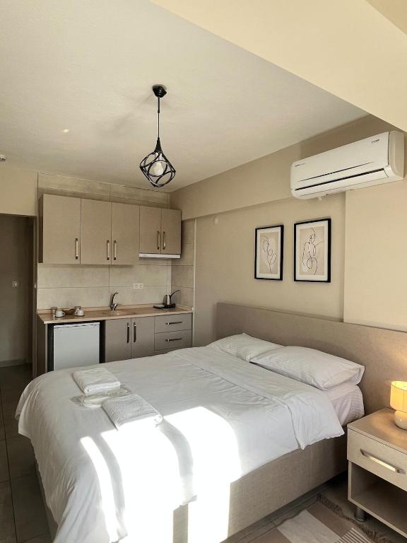 a bedroom with a large white bed and a kitchen at Daily-Weekly-Monthly in Kötekli Center 