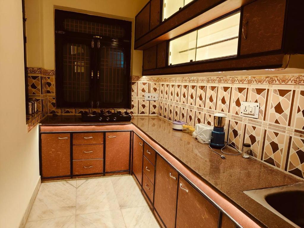 a kitchen with wooden cabinets and a counter top at Urban Retreat in Agra