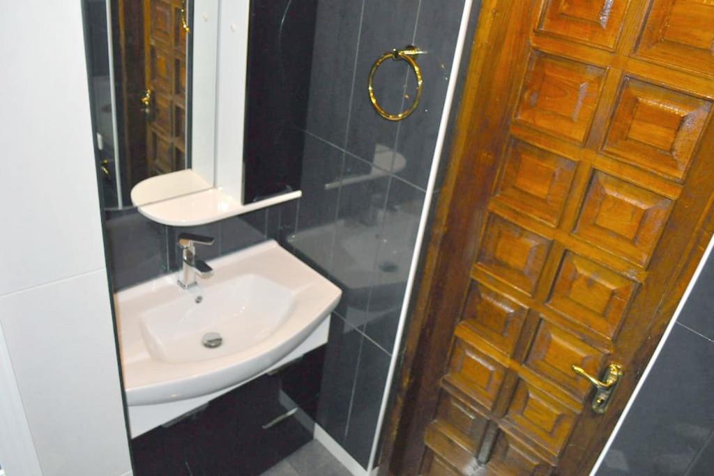 a bathroom with a sink and a mirror and a door at Beauty in the Heart of the City in Tbilisi City
