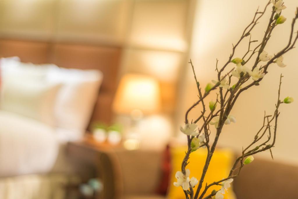 a vase with white flowers in a room at Luxus Grand Hotel in Lahore