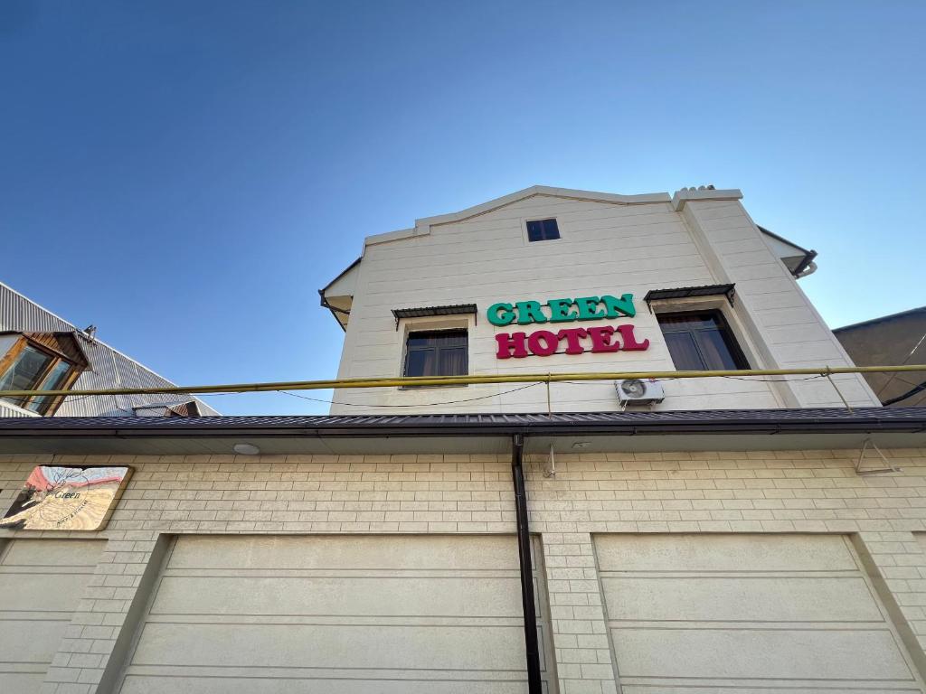 a white building with a green hotel sign on it at The green regency in Toshkent-Passajir Bekati
