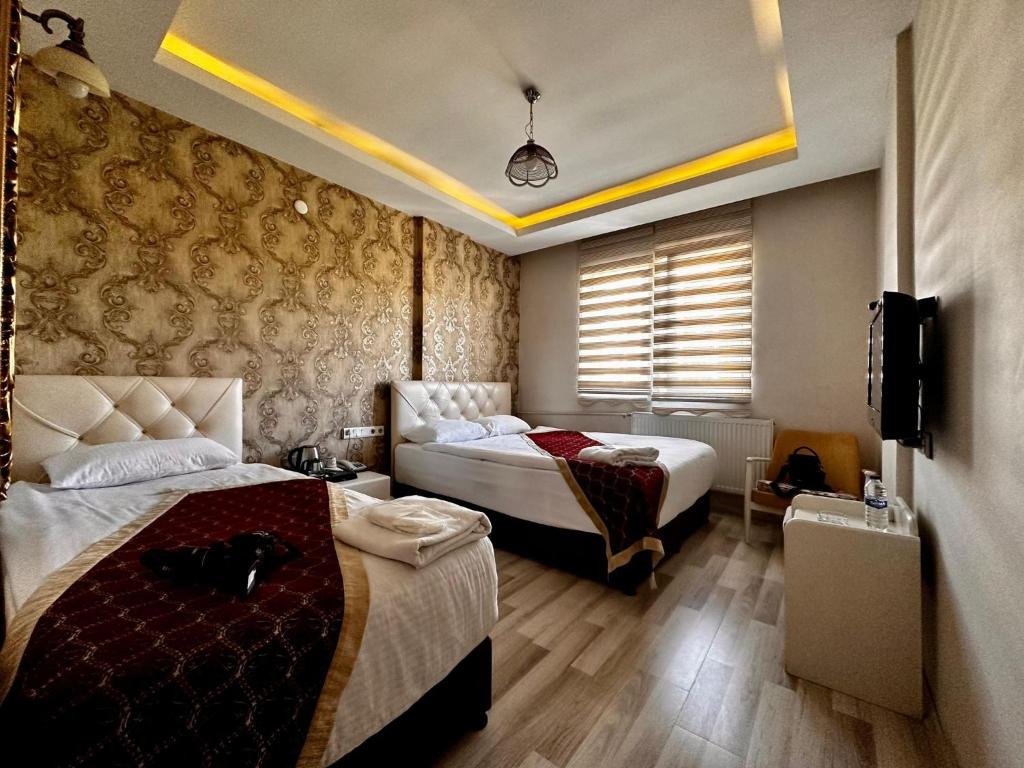 a hotel room with two beds and a television at Hotel seven park in Nevsehir