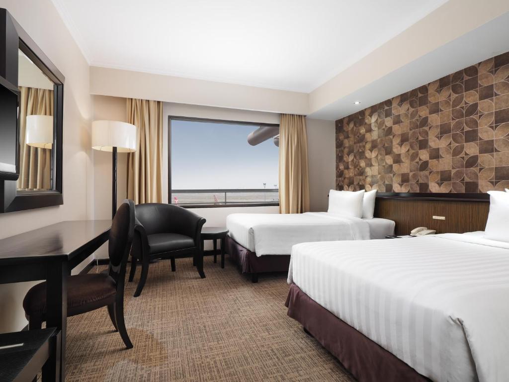a hotel room with two beds and a window at Jakarta Airport Hotel in Rawabagol