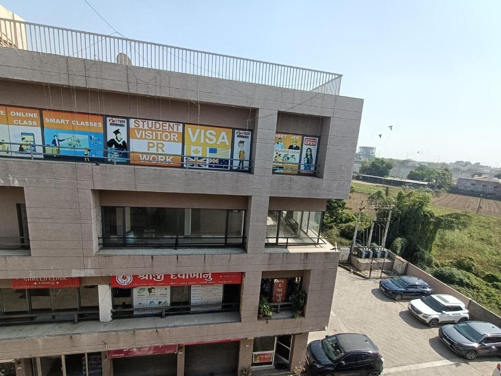 um prédio com carros estacionados em um estacionamento em Hotel Sanwariya em Gandhinagar