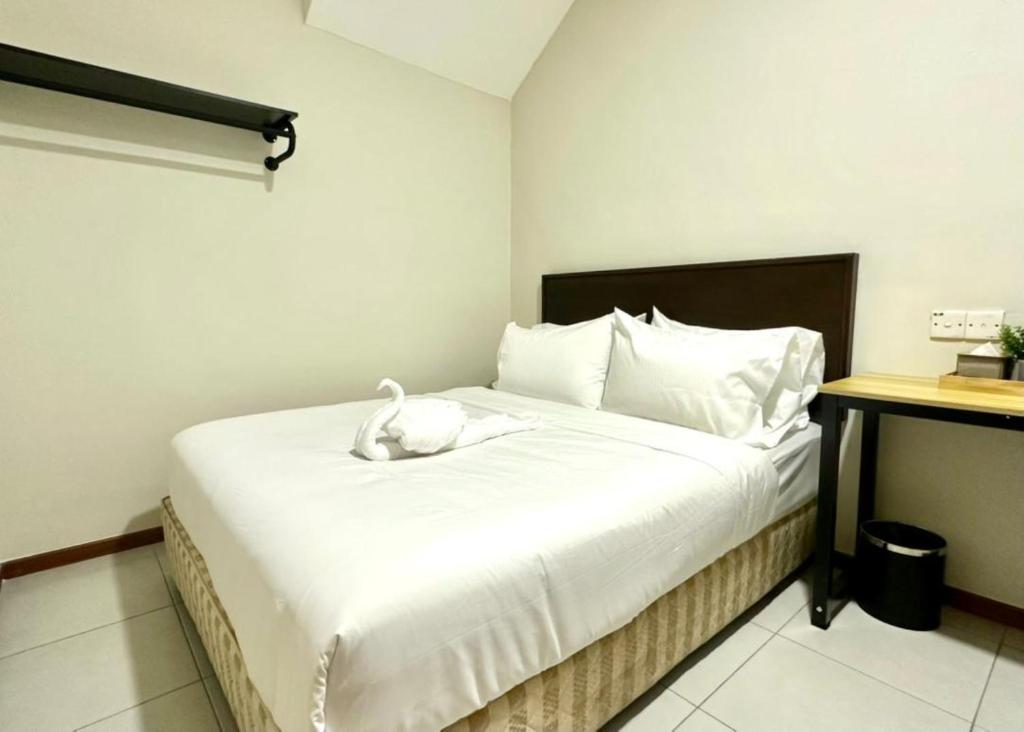 a bedroom with a white bed with a white animal on it at Swing & Pillows - Salak Tinggi , KLIA 1 KLIA 2 in Sepang