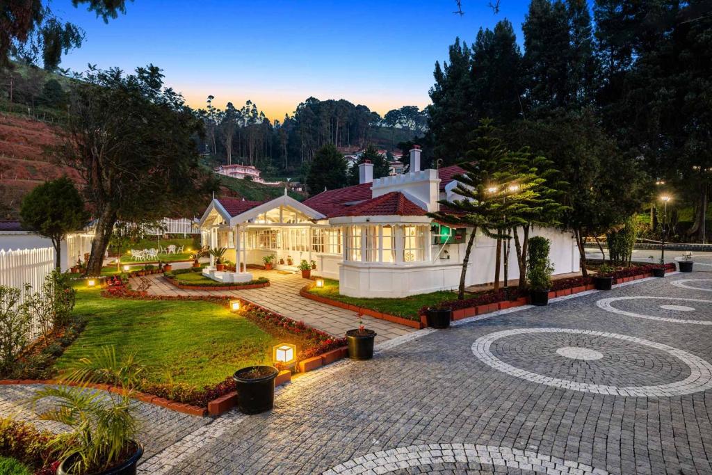 ein großes Haus mit einem Innenhof mit Beleuchtung in der Unterkunft Tiverton Bungalow in Udagamandalam