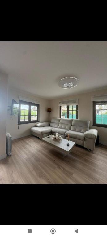 ein großes Wohnzimmer mit Couch und Tisch in der Unterkunft Asturias house in Candás