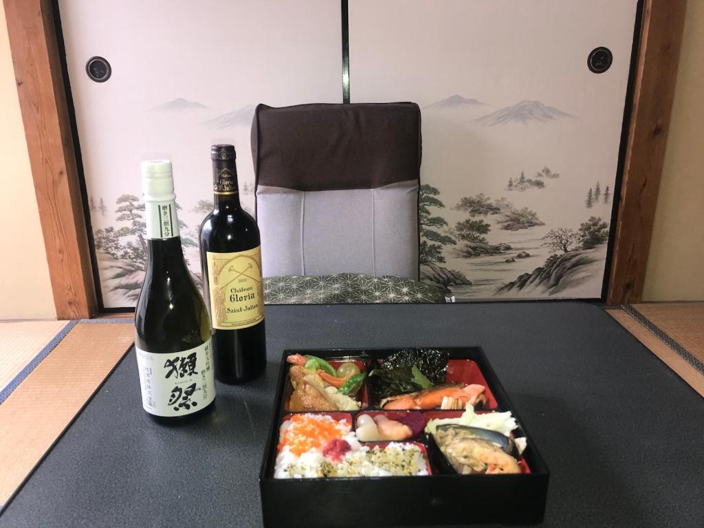 eine Flasche Wein, eine Kiste mit Lebensmitteln und eine Flasche Sake in der Unterkunft YabFarm Lodge 202 in Kashiwa