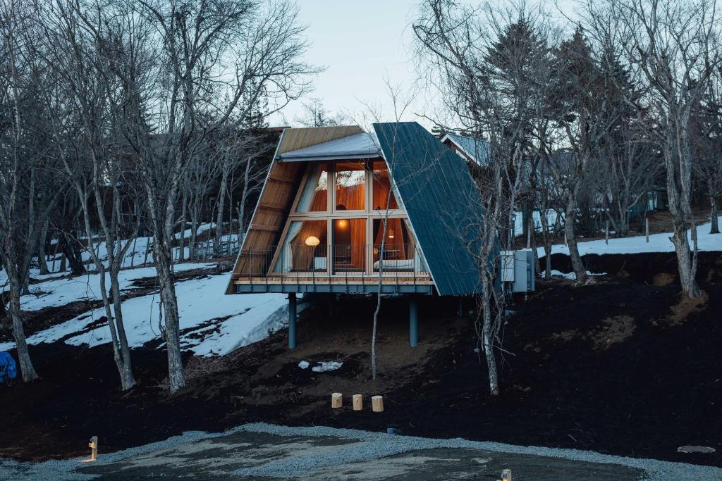a cabin in the woods with a large glass window at SANU 2nd Home 山中湖1st in Yamanakako