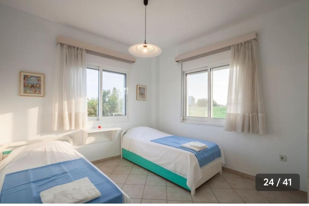 une chambre avec deux lits et deux fenêtres dans l'établissement Haris Papa Villa Kallithea Halkidiki 2, à Afytos