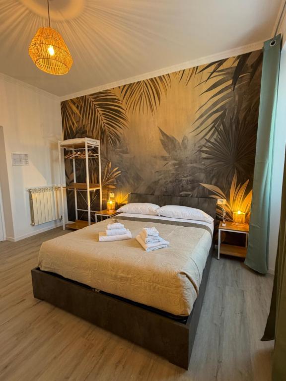 une chambre avec un grand lit avec un tableau au mur dans l'établissement Fly Inn Fiumicino Guest House, à Fiumicino