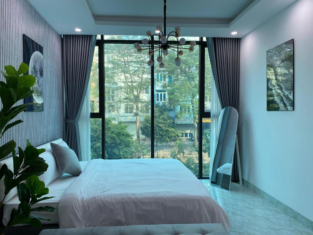 a bedroom with a large bed and a large window at Grand C Homestay in Hanoi