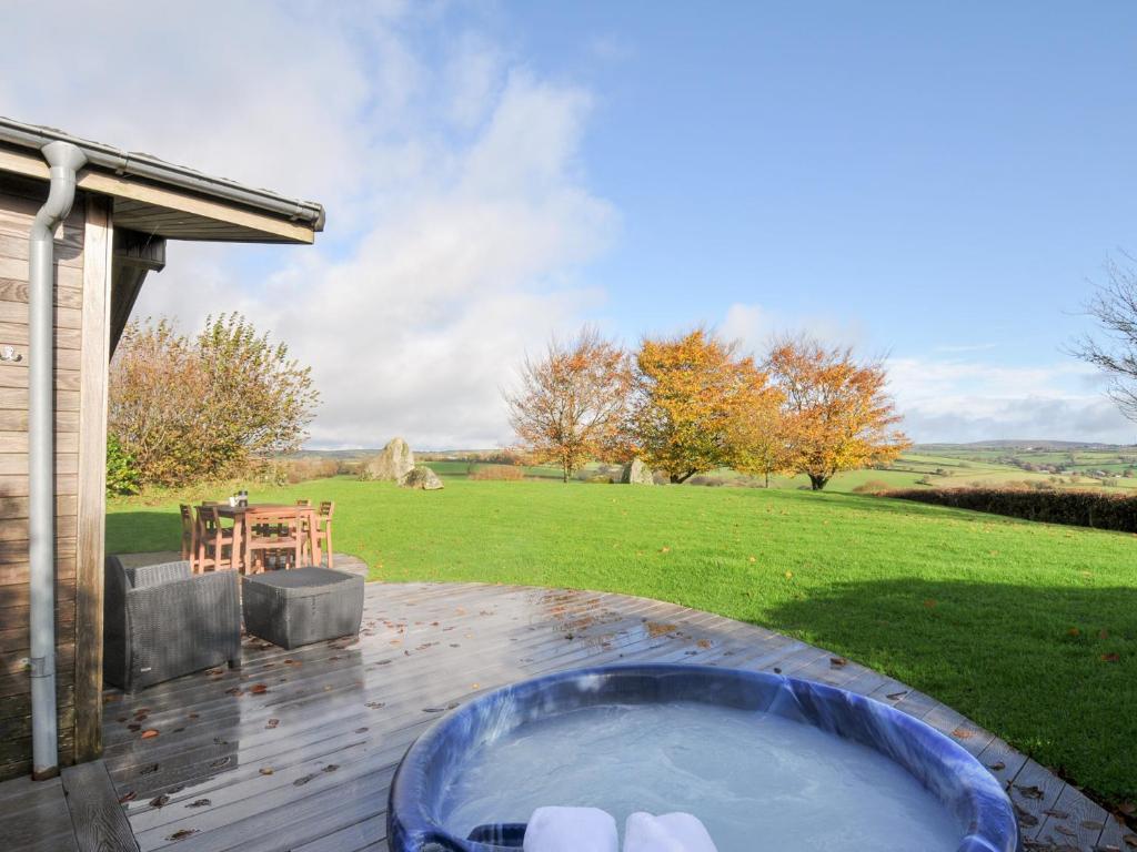 a hot tub on a patio with a yard at 9 Horizon View in Liskeard