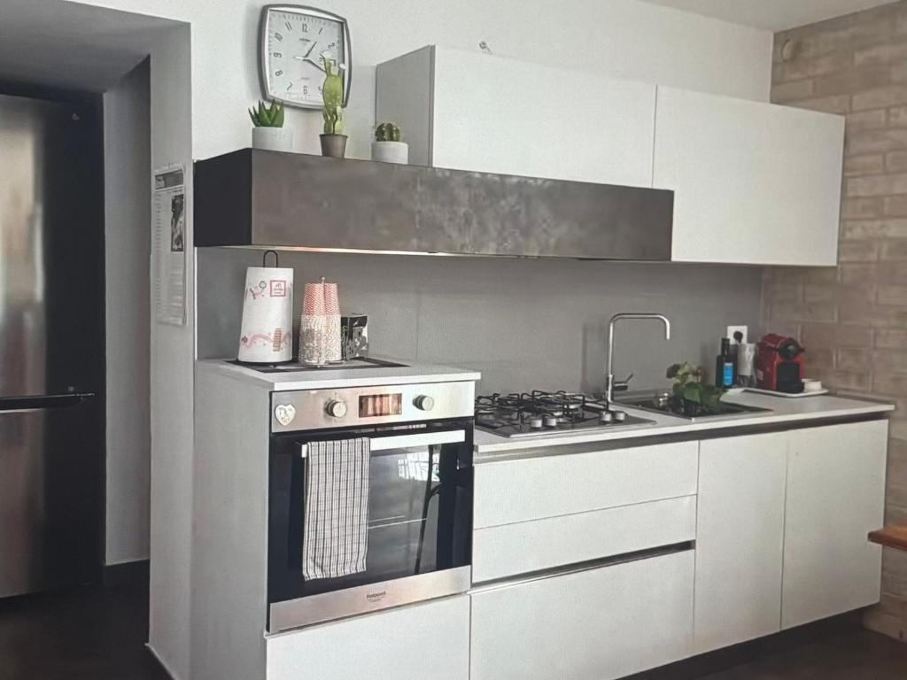 フランカヴィッラ・アル・マーレにあるLa Dolce Ondaのキッチン(コンロ、白いキャビネット付)