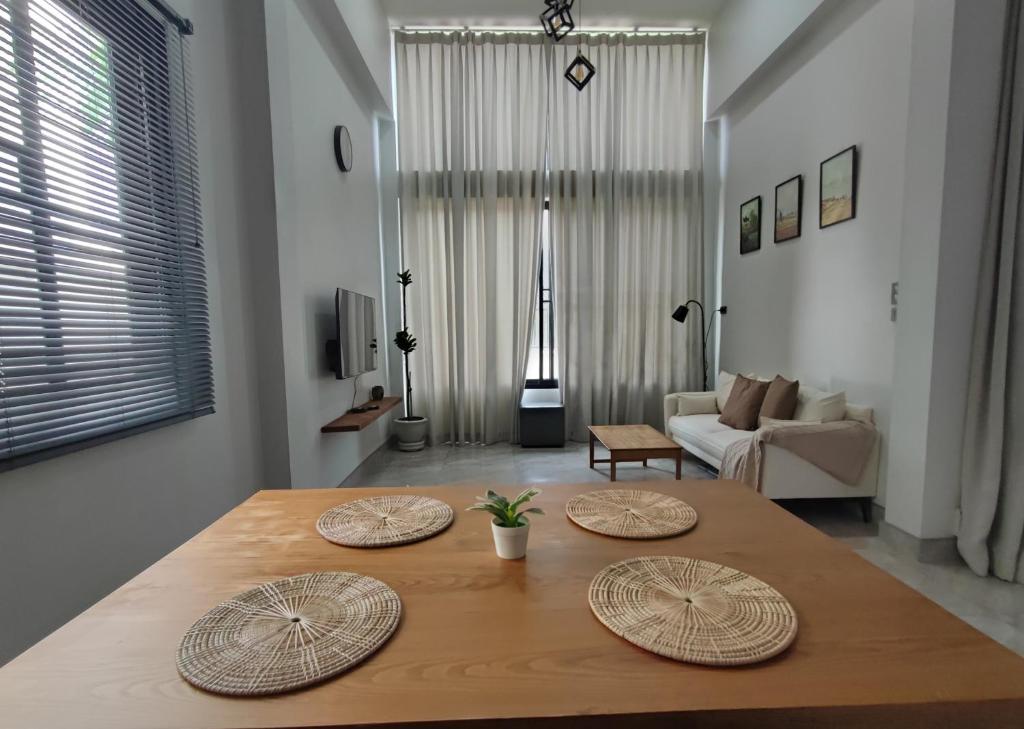 a living room with a table with three plates on it at How Hide Space in Kanchanaburi
