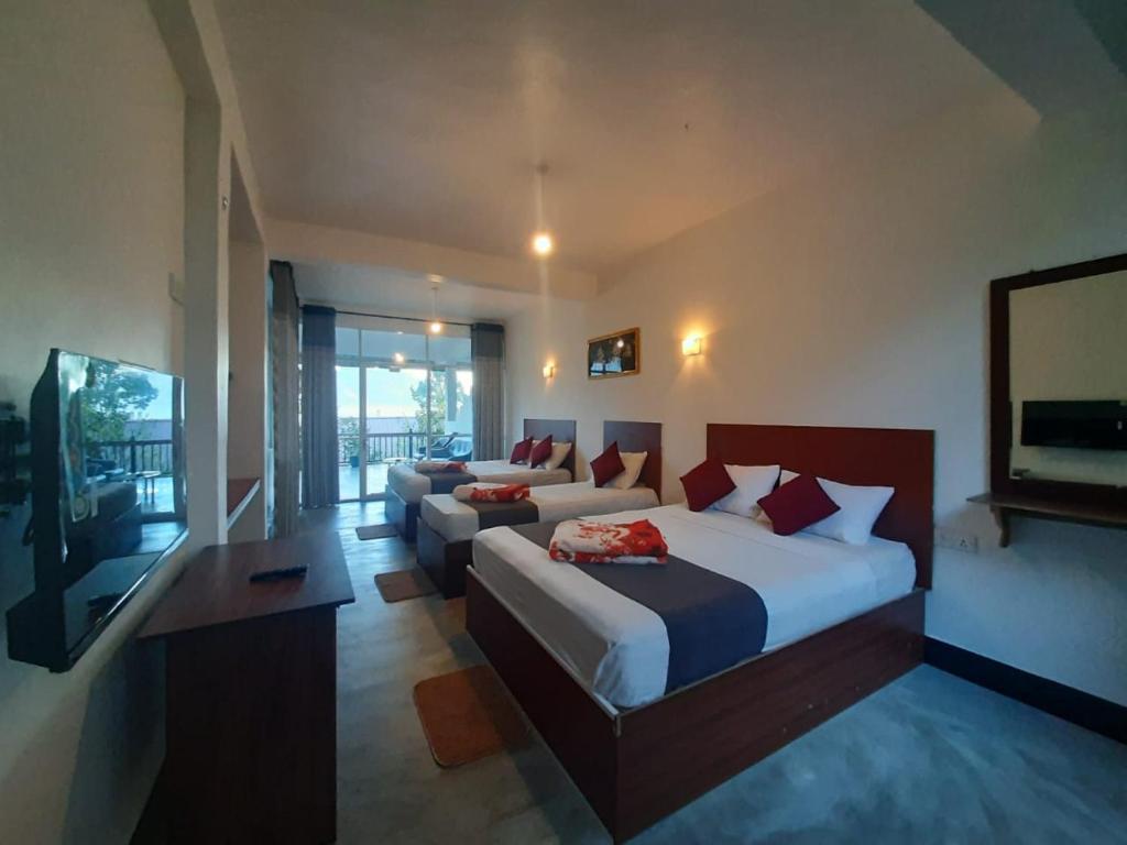 a hotel room with two beds and a couch at Green Villa Ella in Ella