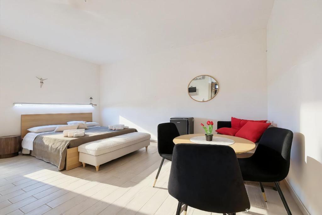 een slaapkamer met een bed, een tafel en stoelen bij Cantine Cippone Room in Monte SantʼAngelo