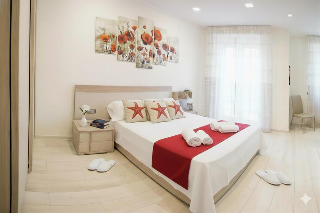 a bedroom with a large white bed with a red blanket at La Terrazza di Andrea in Imperia