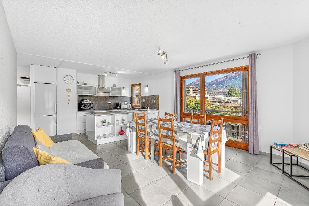 Una cocina y una sala de estar con mesa y sillas. en Appartement T3, en Embrun