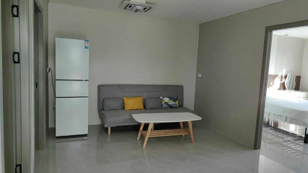 南迪Helen House一间带独立卫生间的温馨卧室的客厅里有一张沙发和一张桌子。