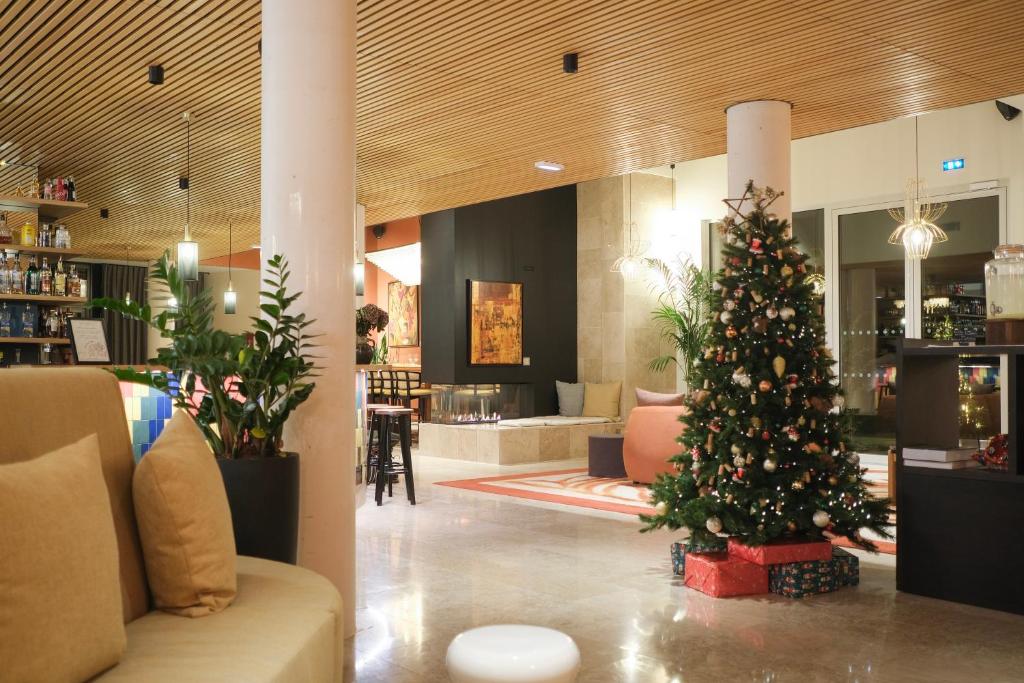 a christmas tree in the middle of a lobby at voco Beaune , Cité des Vins by IHG in Beaune