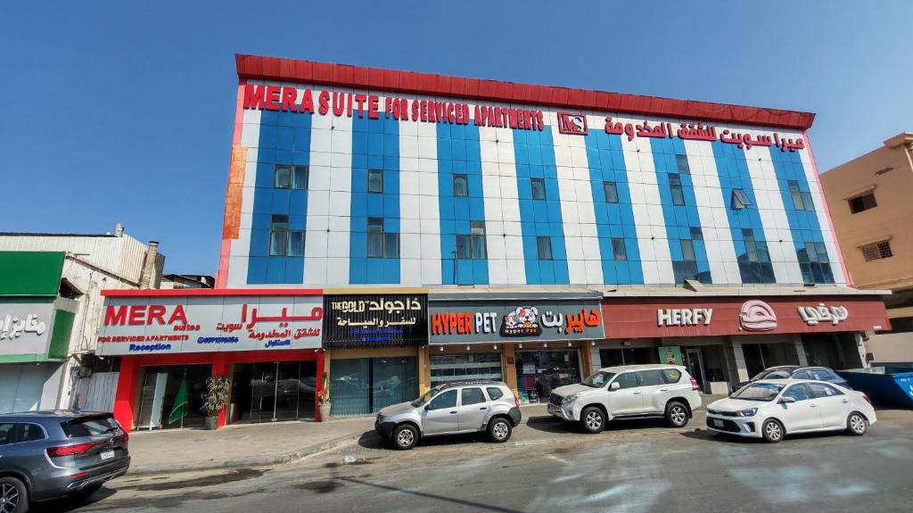 a large building with cars parked in a parking lot at ميرا سويت للشقق المخدومة in Jeddah