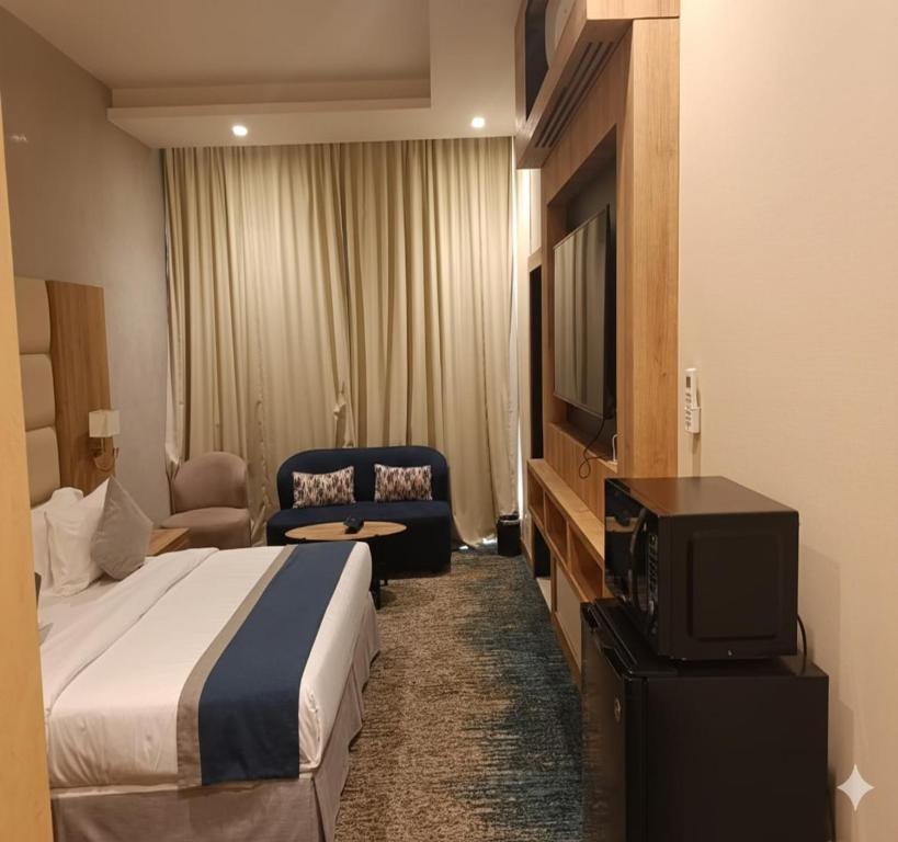 a hotel room with a bed and a tv at Sunday Luxury Central formerly Anan hotel in Riyadh
