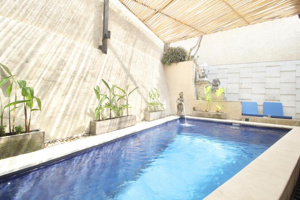 a swimming pool with blue water and blue chairs at 2 Bedrooms Private Pool Villa Lovina in Buleleng