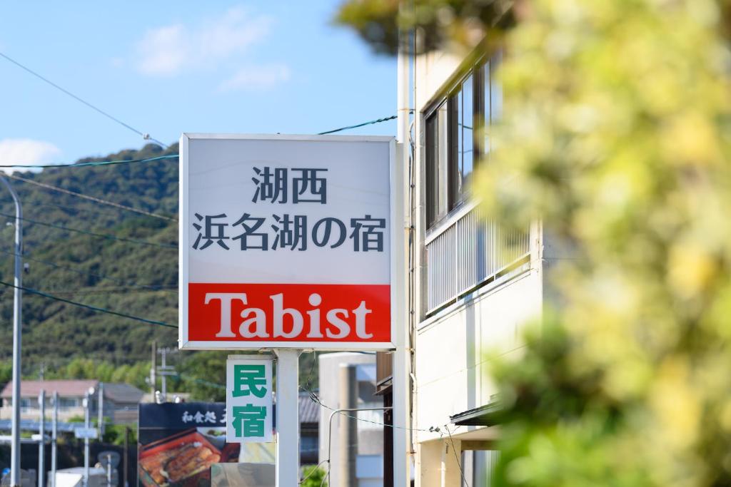 een bord voor een smakeloos restaurant op de zijkant van een gebouw bij Tabist Hamanako no Yado Kosai in Kosai