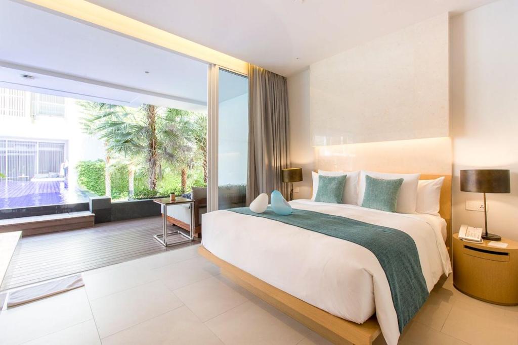 une chambre avec un grand lit et une grande fenêtre dans l'établissement Ace of Hua Hin Resort - Two Bedroom Ace Suite Pool Access, à Sathani Huai Sai Tai