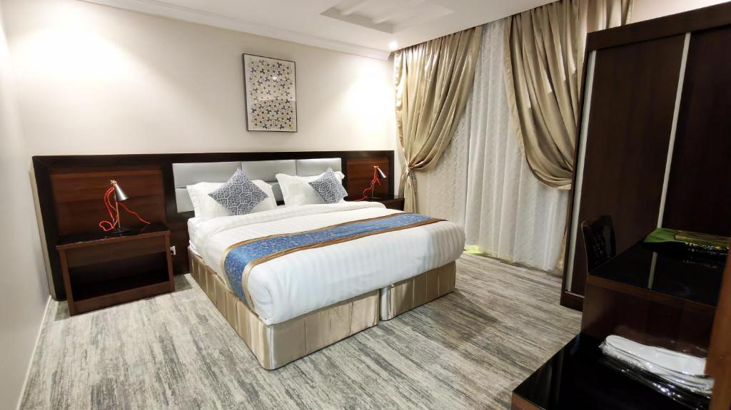 a hotel room with a large bed and a window at الفرسان المتحده للشقق المخدومه الفيصليه ALFURSAN ALMOTAHIDA ALFAISALIA dist in Jeddah