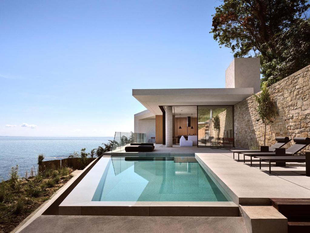 una casa con piscina frente al océano en Opsis villas, A beachfront & architectural retreat, en Akrotiri