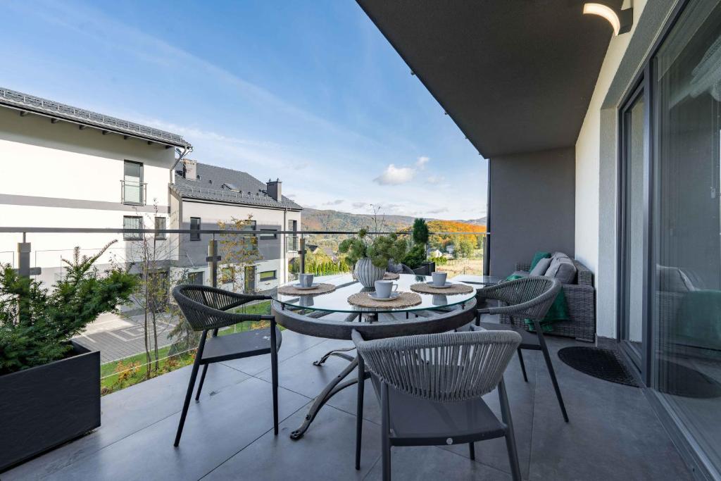 un patio avec une table et des chaises sur un balcon dans l'établissement Apartament Pod Małą Czantorią - Dream Apart, à Ustroń