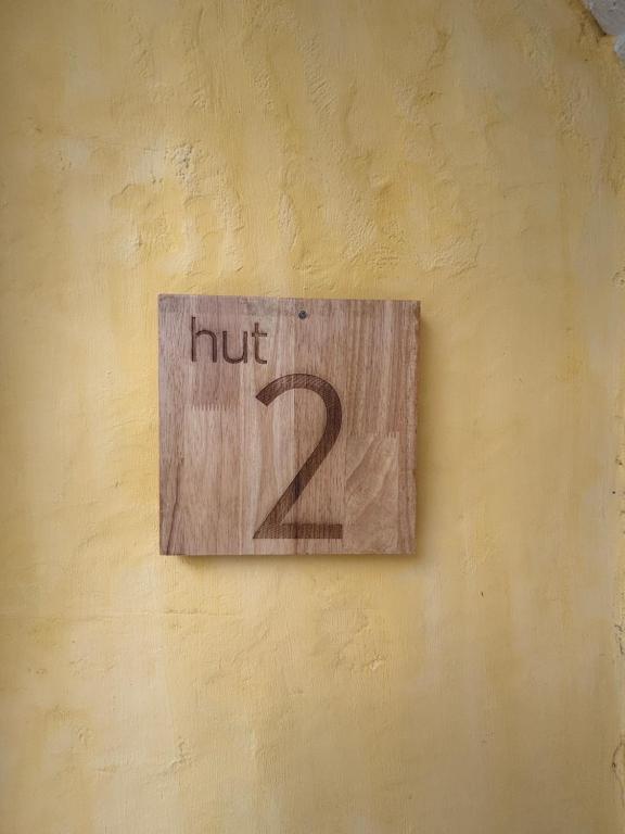 ein Schild mit der Aufschrift "Nut zwei" an einer Wand in der Unterkunft Dehut Boutique Homestay hut2 in Khon Kaen