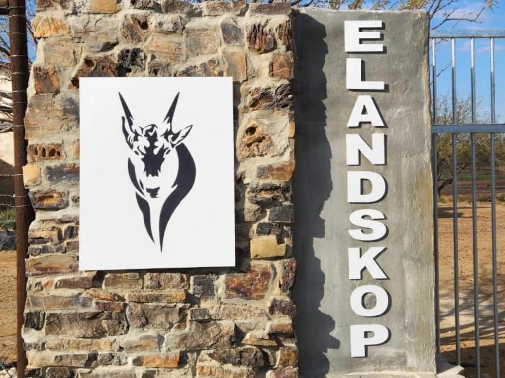 a sign on a wall next to a fence at Elandskop in Breede River DC